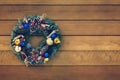 Christmas wreath handmade on a wooden background. Festive lights of garland. New Year`s interior decoration. copy space for text Royalty Free Stock Photo