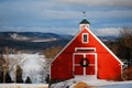 A Christmas wreath hangs on a red barn