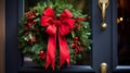 Christmas wreath hanging on a black door with a red bow and berries. It is a festive decoration that symbolizes the Royalty Free Stock Photo