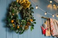 Christmas wreath hanging on blue annoyance wall with lights on it, decor apartment or kitchen