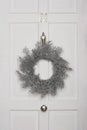 Christmas wreath hanging on white door Royalty Free Stock Photo