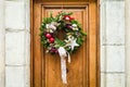 A Christmas wreath hung on a wooden front door Royalty Free Stock Photo