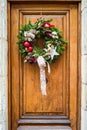 A Christmas wreath hung on a wooden front door Royalty Free Stock Photo