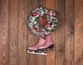 christmas wreath and ice skates on wooden wall Royalty Free Stock Photo