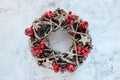 Christmas Wreath Made of branches decorated with gold wooden stars and red berry bubbles on cement background. Creative diy craft Royalty Free Stock Photo