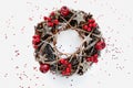 Christmas Wreath Made of branches decorated with gold wooden stars and red berry bubbles on white background. Creative diy craft Royalty Free Stock Photo