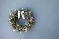 Christmas wreath made of natural fir branches  hanging on a grey wall.  Wreath with natural ornaments: bumps, walnuts, cinnamon, Royalty Free Stock Photo