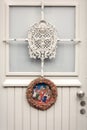 Christmas wreath made of plaster with Christmas scene attached to a white door of a house Royalty Free Stock Photo