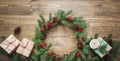 Christmas wreath made of spruce branches with gifts on wooden board. Flat lay. Top view. Royalty Free Stock Photo