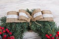 Christmas wreath of pine with red elements on a white wooden background. Macro Christmas wreath on a white wooden background