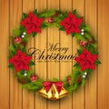 Christmas wreath with red balls decorations, flower and gold bells on wood texture background Royalty Free Stock Photo