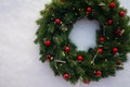 Christmas wreath with red spruce balls on a background of white snow Royalty Free Stock Photo