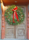 Christmas wreath with red and white bow, pine cones and red berries hanging on doors Royalty Free Stock Photo