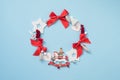 Christmas wreath with red and white decorations on pastel blue background. New year concept. Royalty Free Stock Photo