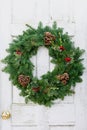 Christmas wreath on rustic white door Royalty Free Stock Photo