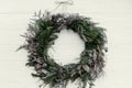 Christmas wreath. stylish rustic christmas wreath on white wooden door with pine cones,fir branches,snow. space for text. Royalty Free Stock Photo