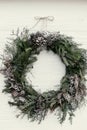Christmas wreath. stylish rustic christmas wreath on white wooden door with pine cones,fir branches,snow. space for text. Royalty Free Stock Photo