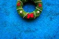 Christmas wreath traditional, classic type. Wreath made of spruce branches and red ribbons on blue background top view