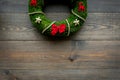 Christmas wreath traditional, classic type. Wreath made of spruce branches and red ribbons on dark wooden background top