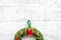 Christmas wreath traditional, classic type. Wreath made of spruce branches and red ribbons on white wooden background