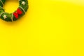 Christmas wreath traditional, classic type. Wreath made of spruce branches and red ribbons on yellow background top view