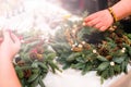 Christmas wreath weaving workshop. Woman hands decorating holida