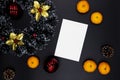 Christmas wreath and white paper card on black background. Blank card with text place. Christmas decor top view Royalty Free Stock Photo