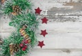 Christmas wreath on wooden rustic background flat lay. Traditional christmas wreath with red berries and ornaments, pine cones and Royalty Free Stock Photo