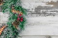 Christmas wreath on wooden rustic background flat lay. Traditional christmas wreath with red berries and ornaments, pine cones and Royalty Free Stock Photo