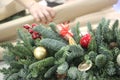 Christmas wrest with baubles and Woman wrapping modern Christmas gifts presents defocused Royalty Free Stock Photo