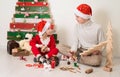 Christmas, x-mas, New Year, winter, holiday concept - smiling children in santa hats near creative wooden Christmas tree making