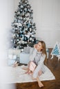 Christmas, x-mas, winter, happiness concept - smiling woman with many gift boxes. Girl opens a gift against the Royalty Free Stock Photo