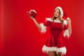 Christmas, x-mas, winter, happiness concept - smiling woman in santa helper hat with gift box, over red background Royalty Free Stock Photo