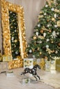 Christmas xmas casual gold studio decorations with cute girl and huge mirror with golden frame plenty presents and big green pine
