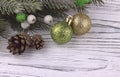 Christmas Xmas New Year holiday background with golden gift box green and gold balls natural fir branches cones on white wooden ba Royalty Free Stock Photo