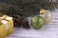 Christmas Xmas New Year holiday background with golden gift box green and silver balls natural fir branches cones on white wooden Royalty Free Stock Photo