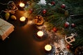 Christmas. Xmas toys, burning candles and spruce branch on black background top view. Space for text