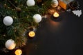 Christmas. Xmas toys, burning candles and spruce branch on black background top view. Space for text Royalty Free Stock Photo