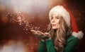 Christmas. Young woman blowing snowflakes from her hands. Royalty Free Stock Photo