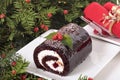 Christmas yule log cake on plate under tree with napkin