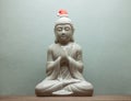 Christmass Buddha in red santa hat on blue background Royalty Free Stock Photo