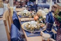Christmastime table setting, festive dinnerware decorated with details and white balls in Blue and Gold colors. Navy Blue Table Royalty Free Stock Photo