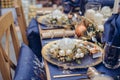 Christmastime table setting, festive dinnerware decorated with details and white balls in Blue and Gold colors. Navy Blue Table Royalty Free Stock Photo