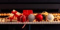 Chritmas balls and gift boxes on piano keyboard, front view