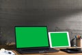 Chroma key green screen, angled view laptop and digital tablet on table. with creative tools