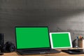 Chroma key green screen, angled view laptop and digital tablet on table with digital photography equipment