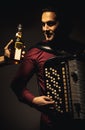 Chromatic Accordion Player And Bottle of Spirit Drink