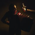 Chromatic Accordion Player And Bottle of Spirit Drink