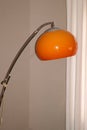 Chrome arc lamp from the 70s with orange plastic lampshade Royalty Free Stock Photo