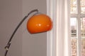 Chrome arc lamp from the 70s with orange plastic lampshade Royalty Free Stock Photo